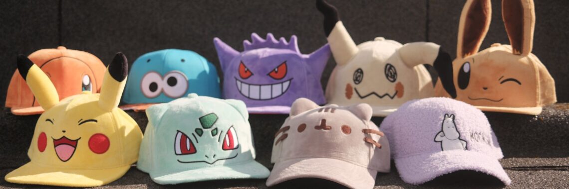 Licensed character merch caps featuring Pokémon and pop culture characters displayed outdoors